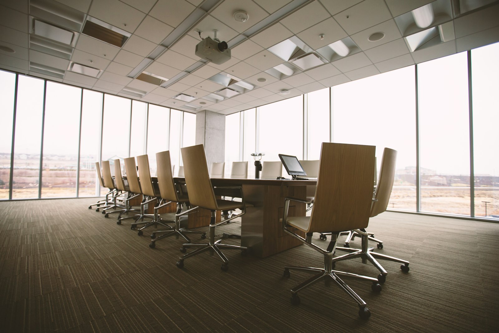 Executive boardroom with a long conference table and floor-to-ceiling glass