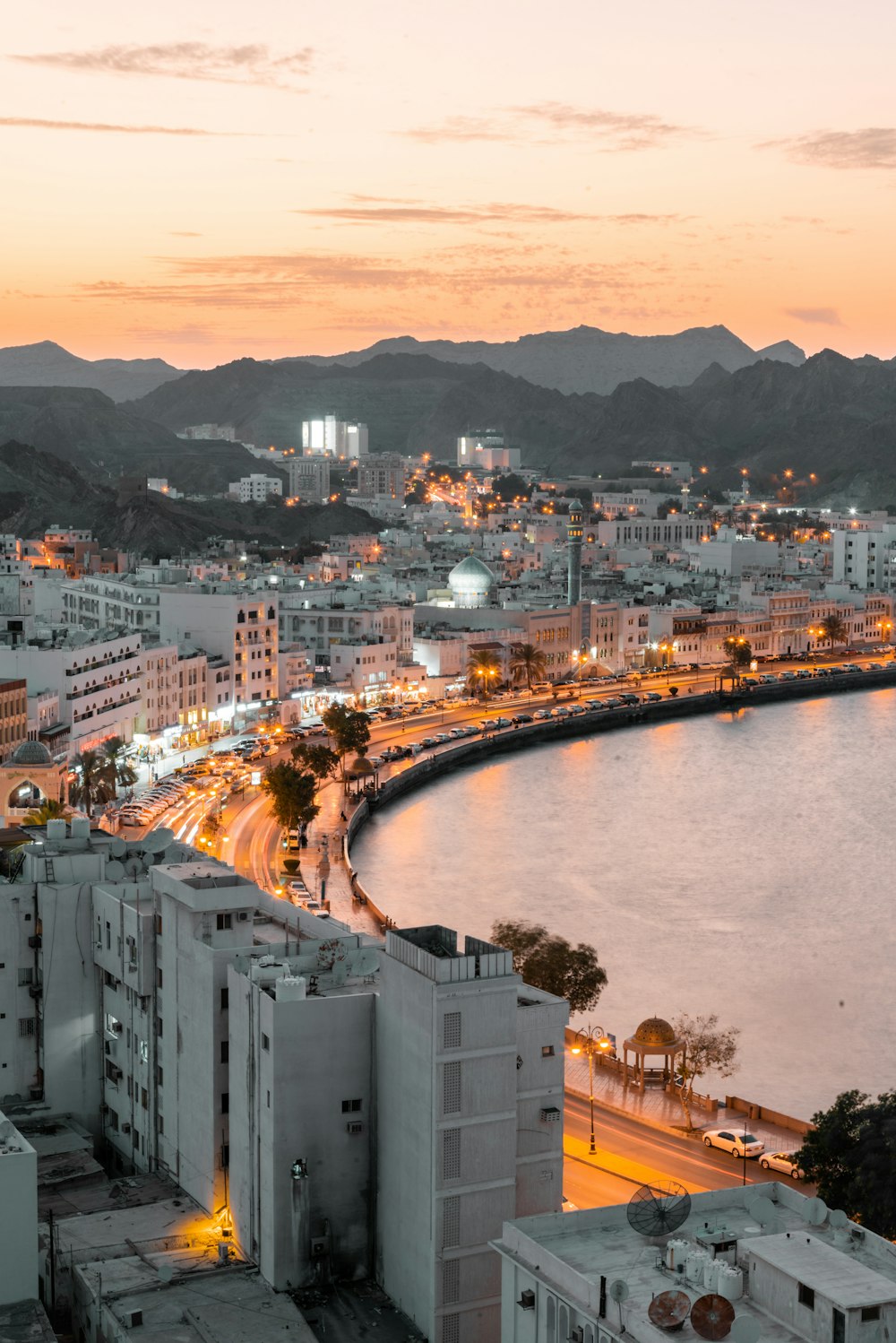 Muscat corniche curving around the bay at dusk